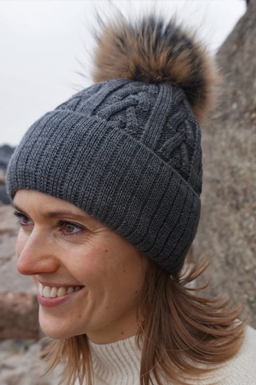 Knitted Hat MARIKA in charcoal with a pom-pom made of Finnish raccoon fur.